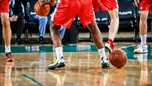 Action de défense sur un écran lors d'un match de basket en salle.