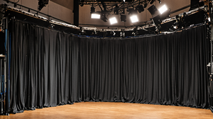 Technicien ajustant un câble sur une scène vide avant un concert