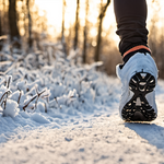 Coureur en hiver avec bonnet et gants sur un chemin de parc au matin