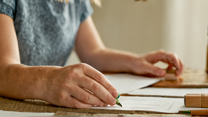 Parent et enfant triant des fournitures scolaires sur une table, scène du quotidien sans marques lisibles.