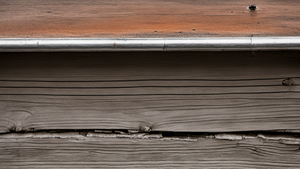 Une personne utilise un ordinateur portable avec un téléphone posé à côté sur un bureau.