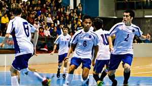 Action de futsal en salle avec un duel proche du but.