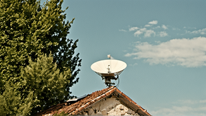 Une antenne satellite installée sur un bâtiment en zone rurale.