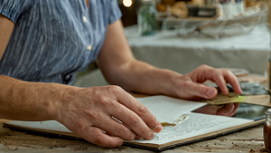 Acheteuse inspectant un ordinateur portable d’occasion sur une table en boutique.