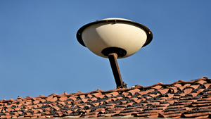 Une parabole internet installée sur un toit avec une ville en arrière-plan.