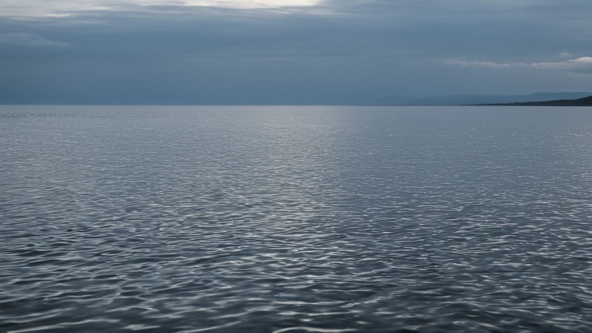 Un lac clair avec une légère onde à la surface près des rochers.
