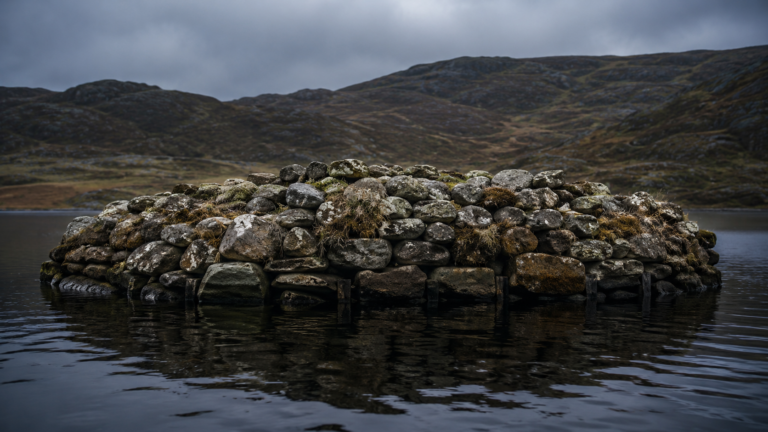 Îlot pierreux dans un loch écossais sombre