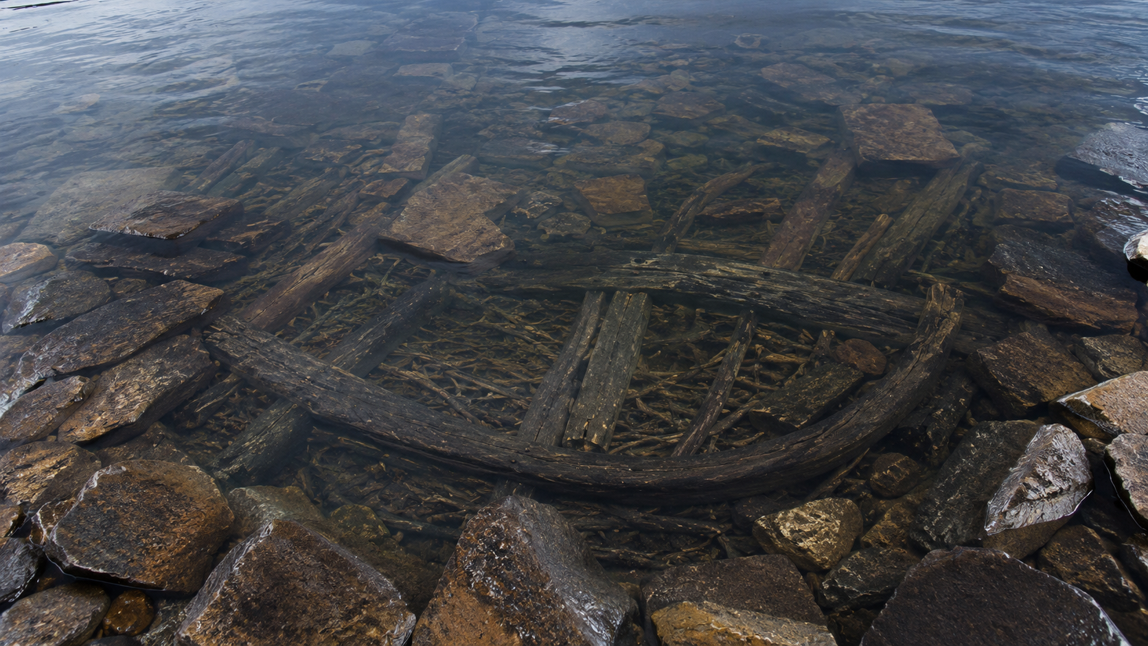 Bois ancien et pierres sous l'eau du loch
