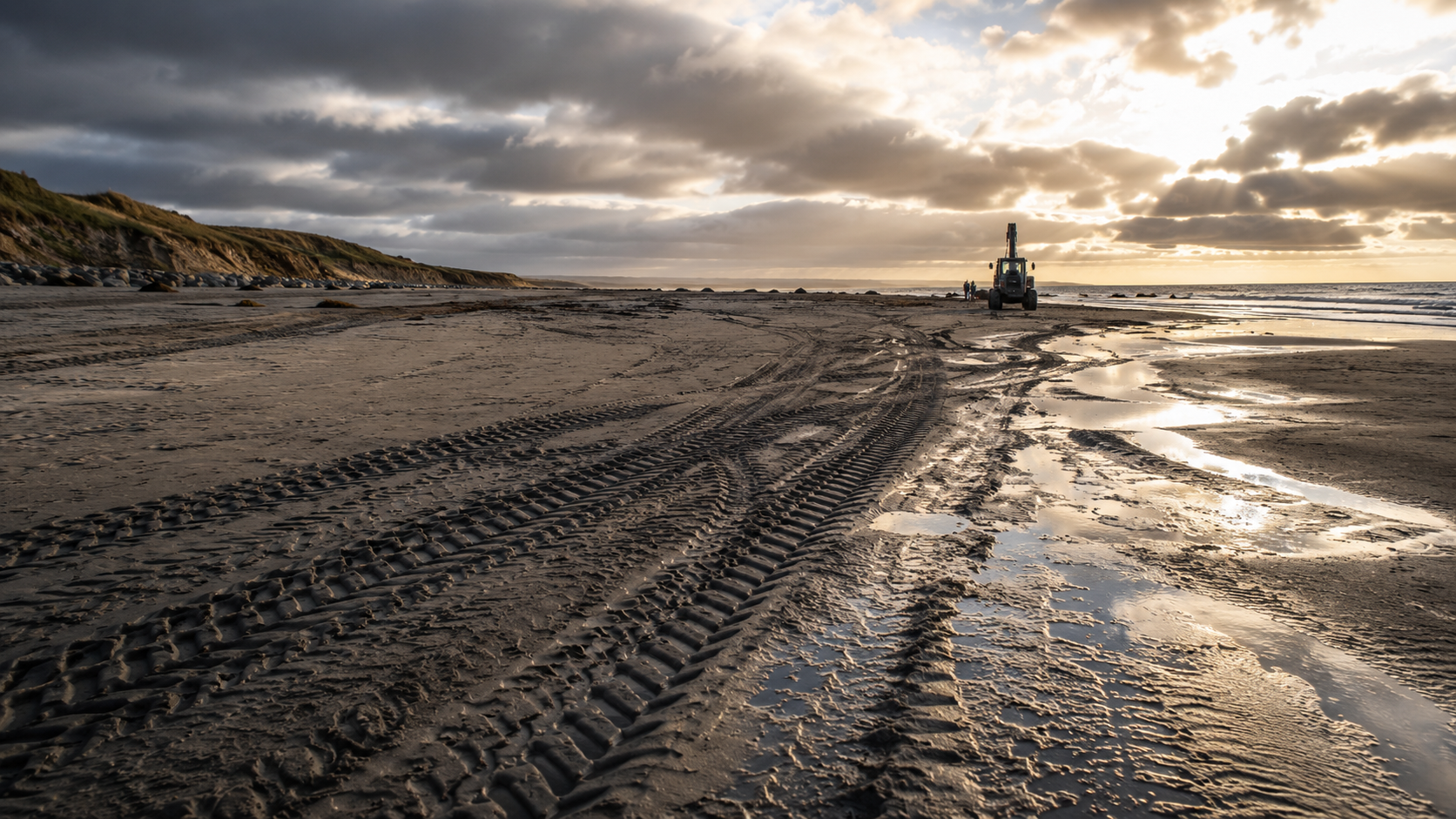 Un littoral atlantique avec traces de pneus et véhicule technique au loin