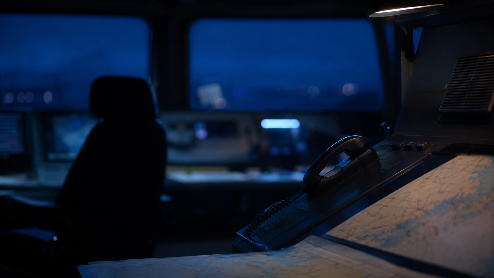 Centre de coordination maritime nocturne avec radios et cartes floues