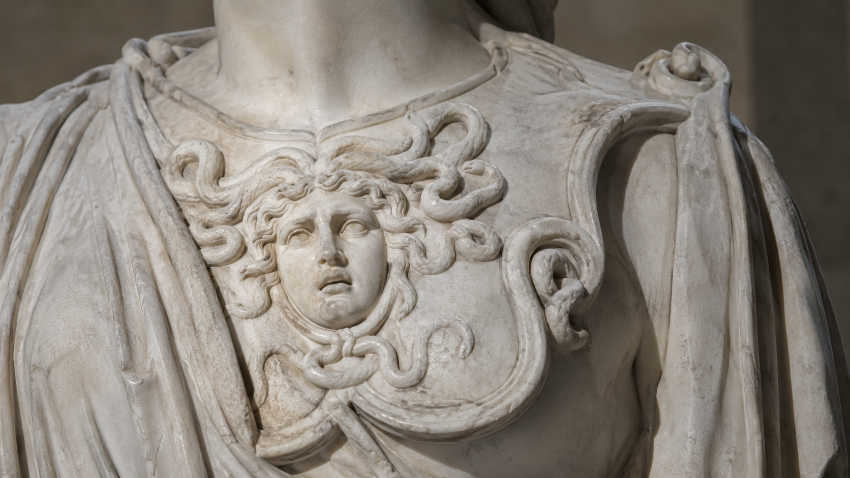 Détail sculpté d'une égide ornée d'une tête de Méduse et de serpents sur une statue de marbre