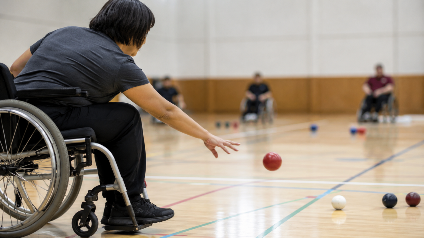 Un joueur de boccia assis lance une boule de cuir vers la cible dans un gymnase