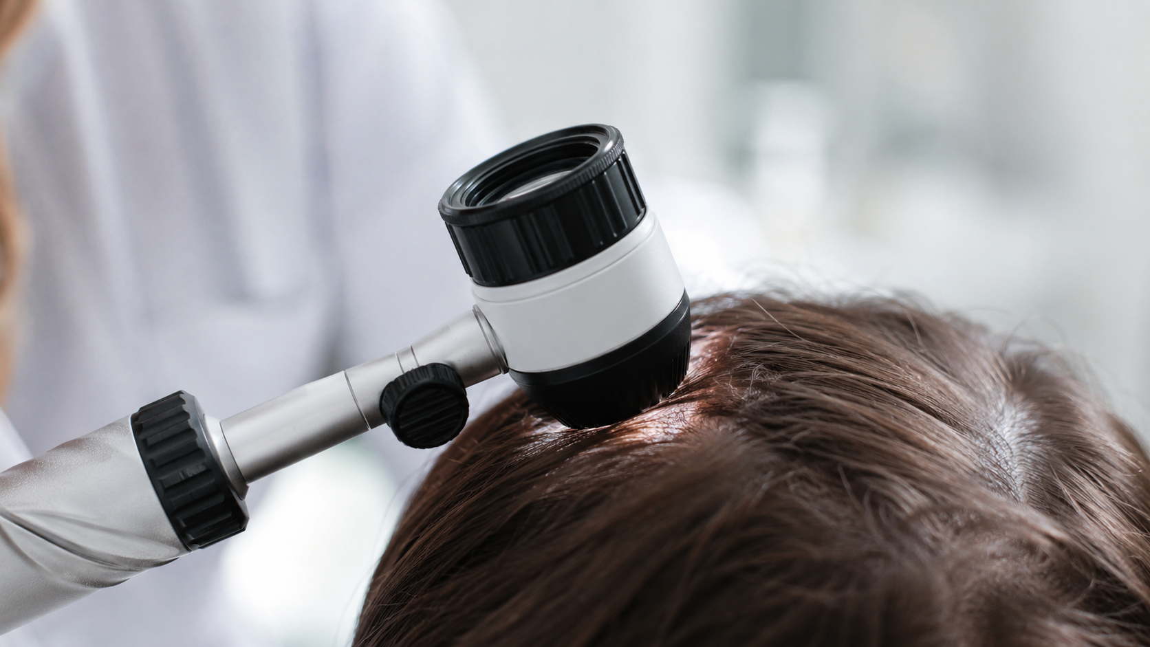 Dermatologue examinant le cuir chevelu d'un patient avec un dermoscope lors d'une consultation