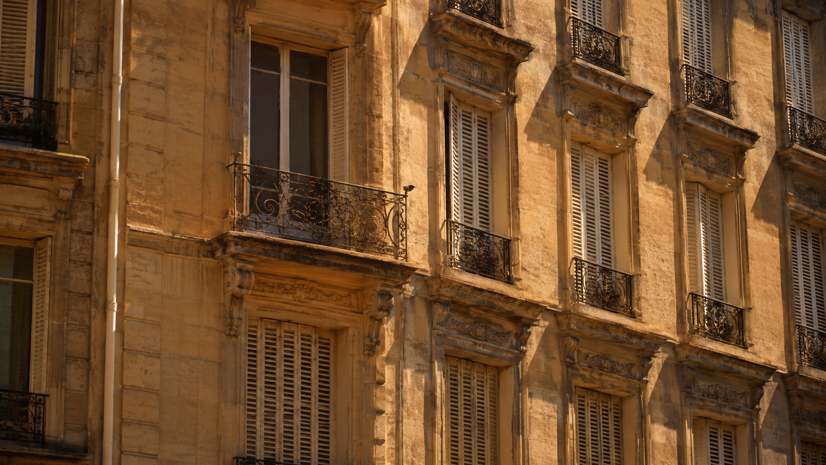 Façade d'immeuble parisien aux volets fermés sous la chaleur, air vibrant d'une vague de chaleur
