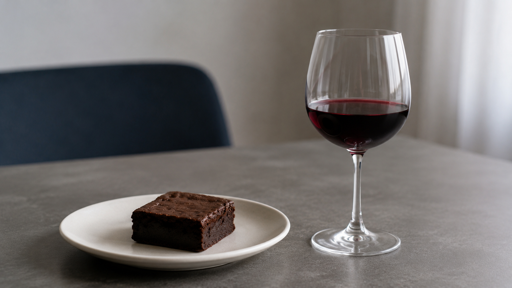 Un brownie et un verre de vin posés sur une table