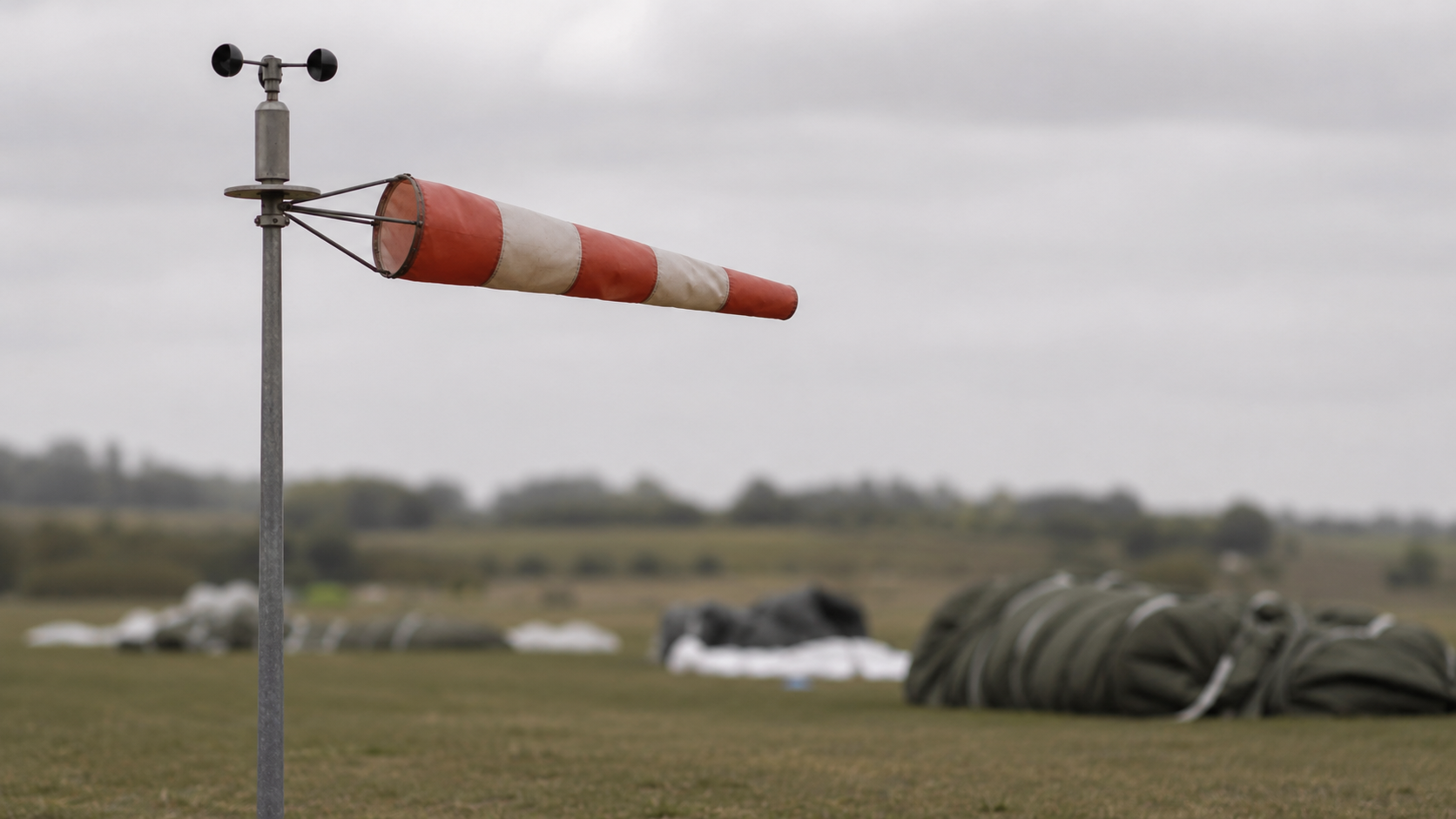 Une manche à air et un anémomètre dans une prairie normande.