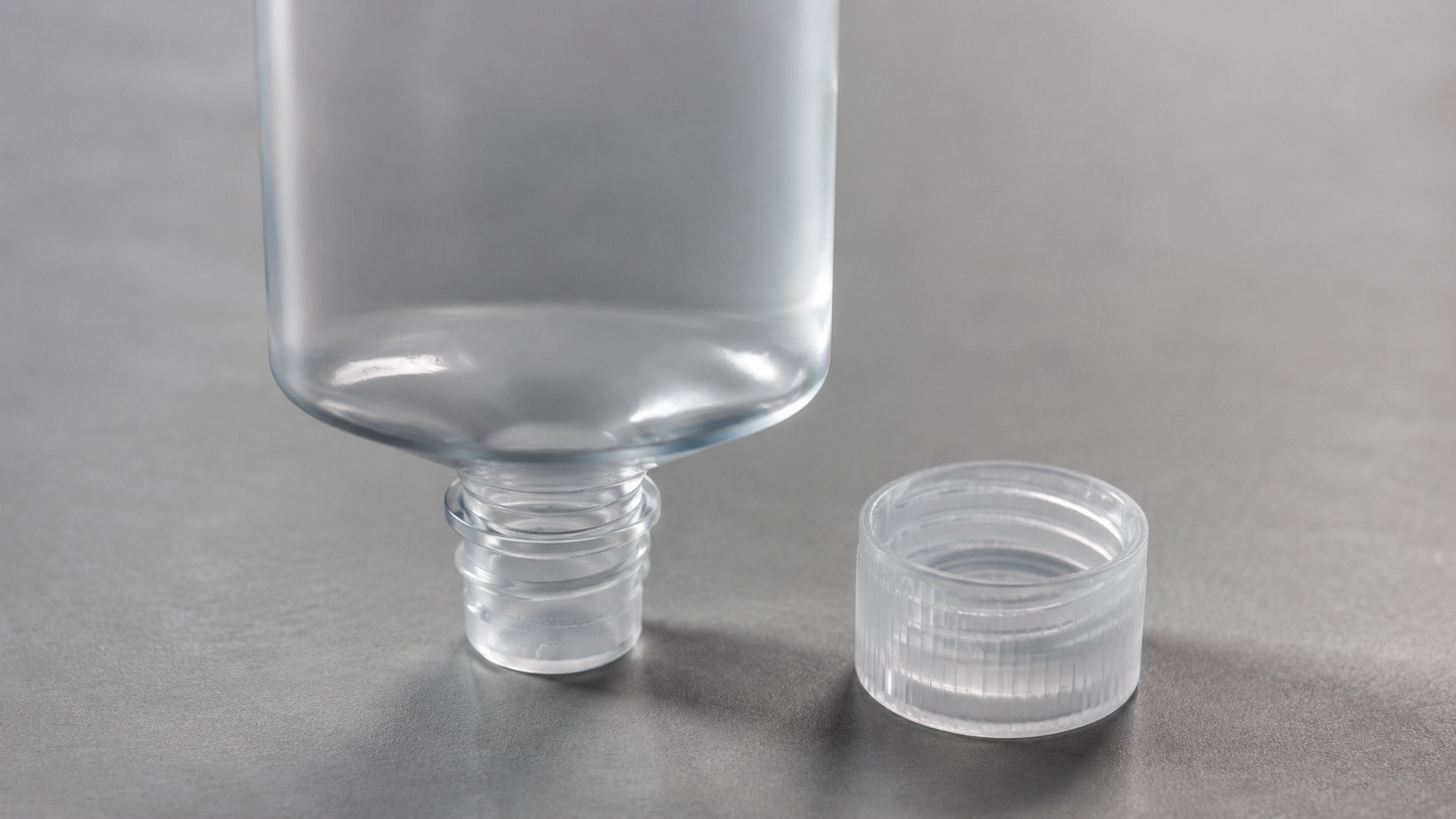 Flacon plastique de cosmétique vide retourné sur fond neutre