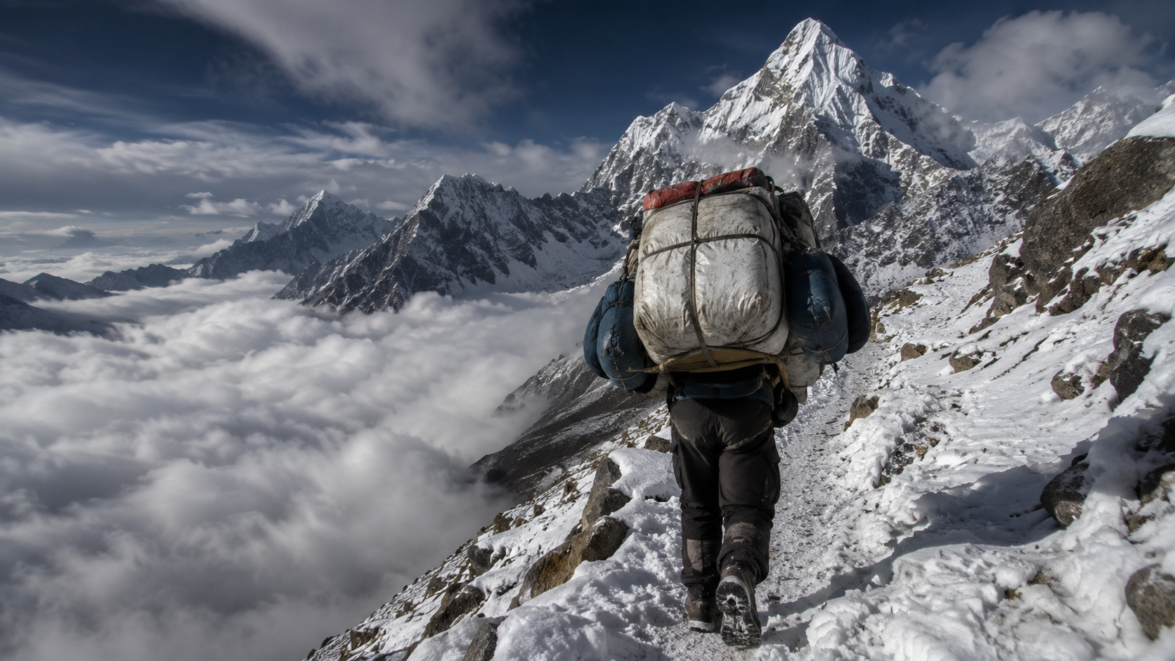 Guide sherpa portant une charge lourde sur un sentier enneige en haute altitude himalayenne