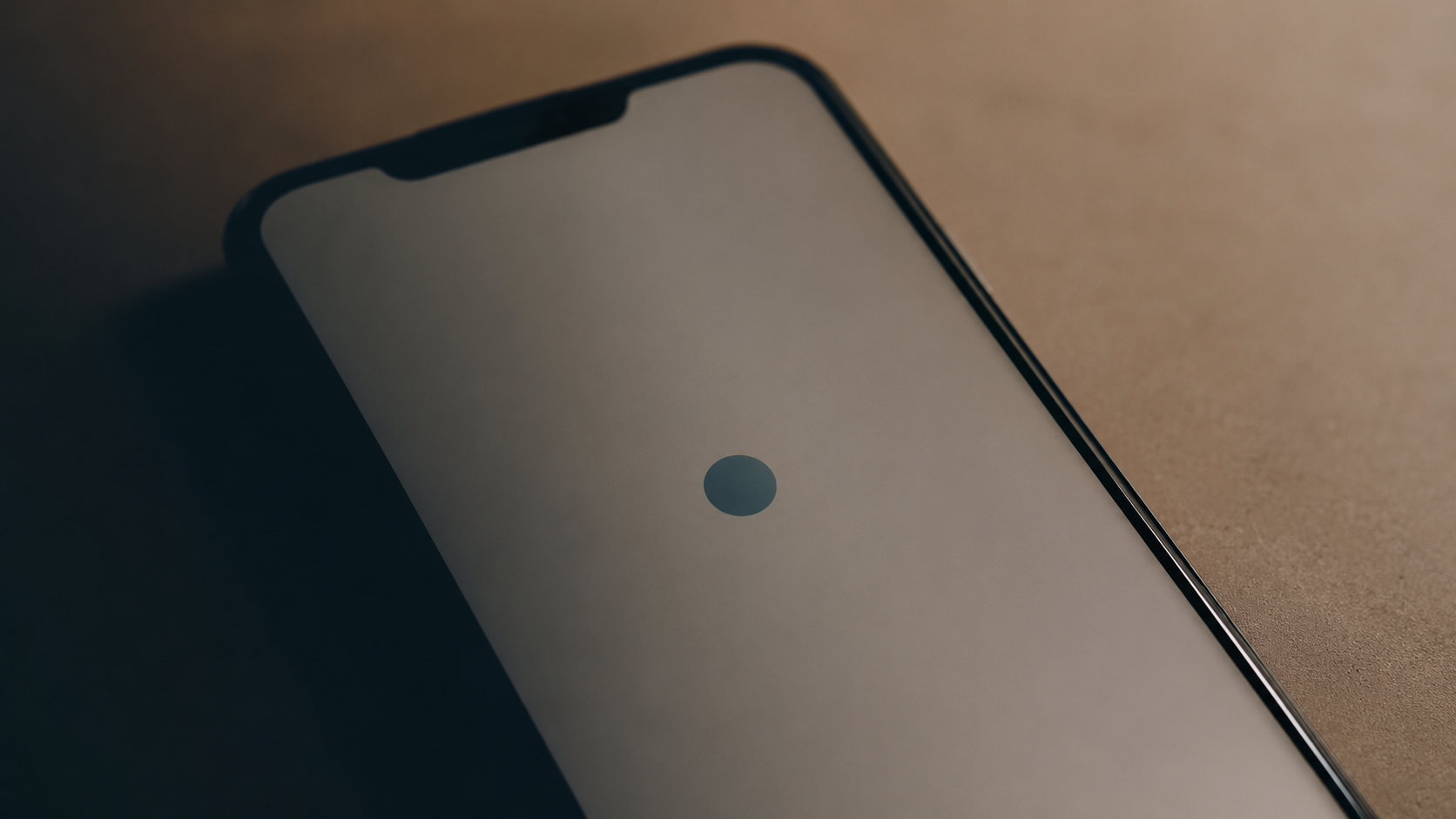 Gros plan d'un ecran de smartphone montrant un point de localisation neutre, partiellement dans l'ombre