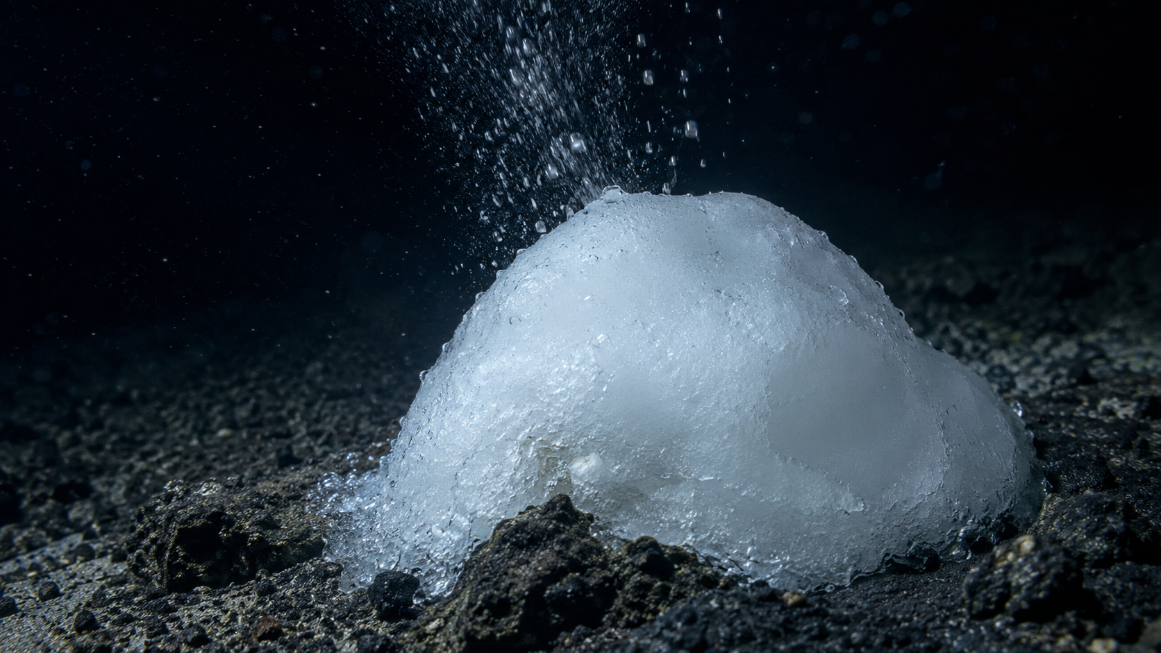 Gros plan d'un dome d'hydrate de CO2 givre laissant echapper des gouttelettes de gaz au fond de l'ocean