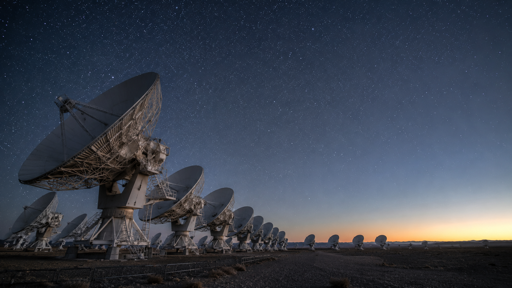 Réseau de radiotélescopes pointant vers un ciel étoilé dans un paysage désertique