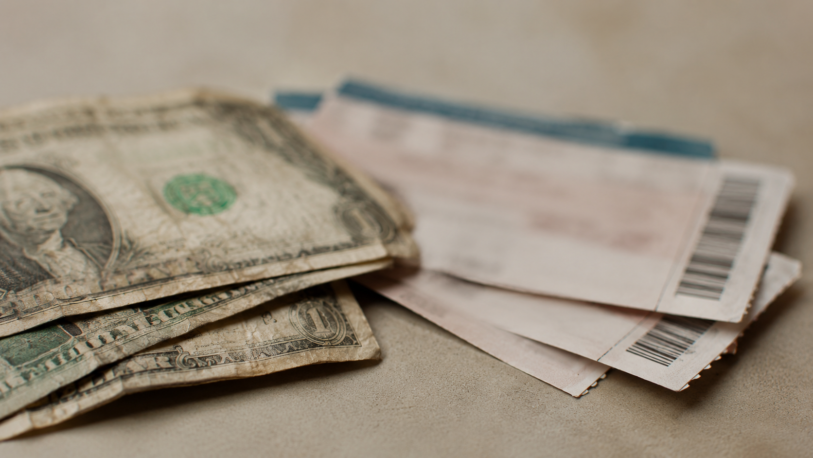 Billets d'un dollar et ticket de concert sur une surface, composition symbolique