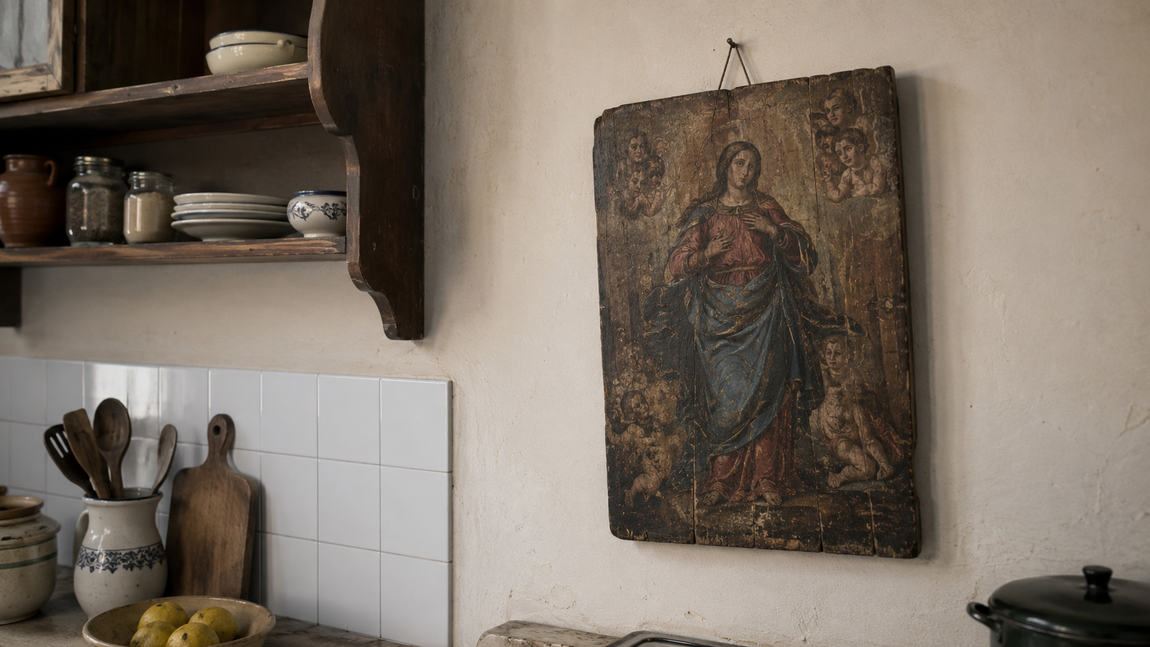 Un petit panneau de bois ancien à scène religieuse, accroché dans une cuisine modeste