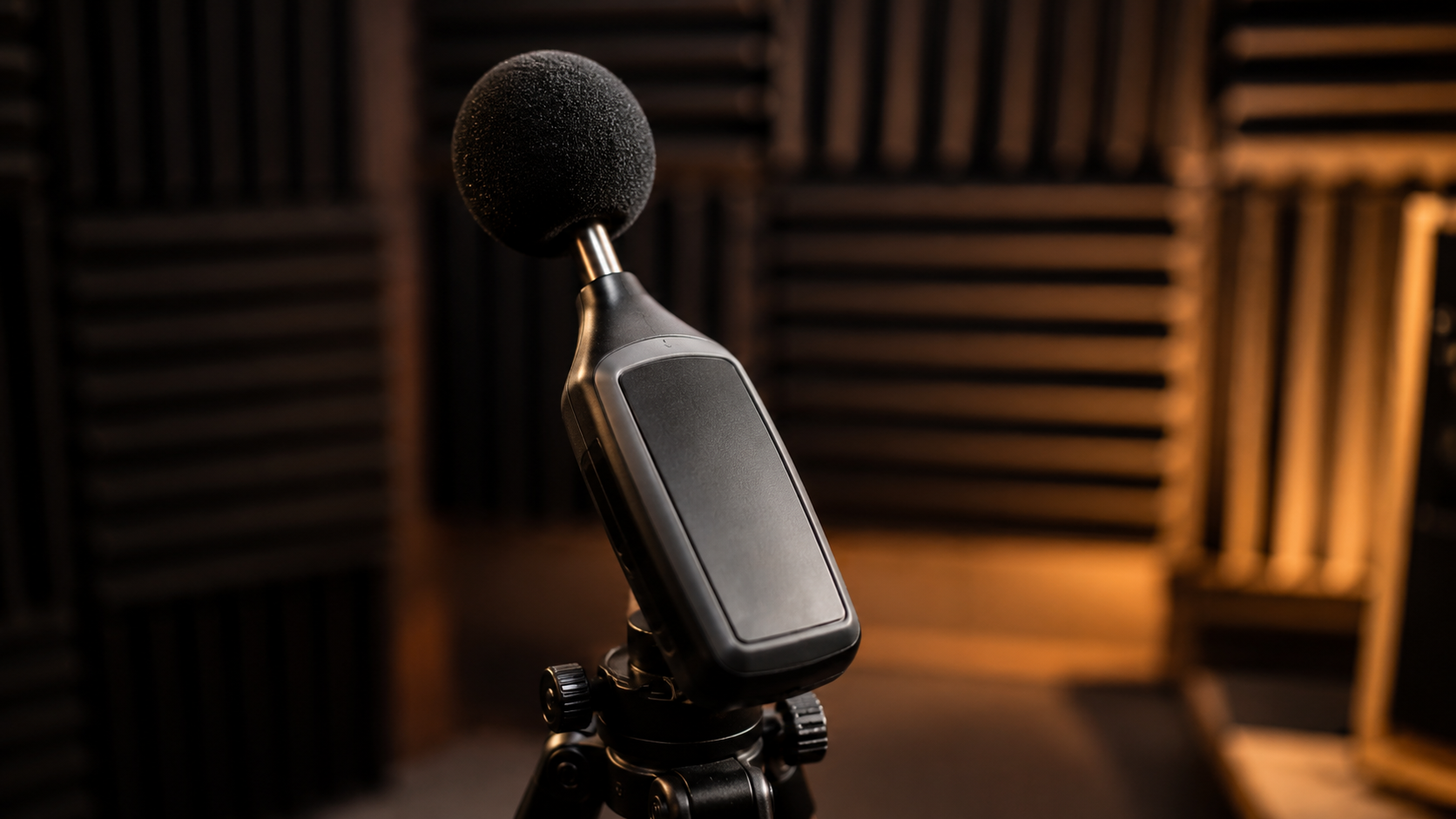 Un sonomètre professionnel sur trépied dans un studio aux panneaux acoustiques