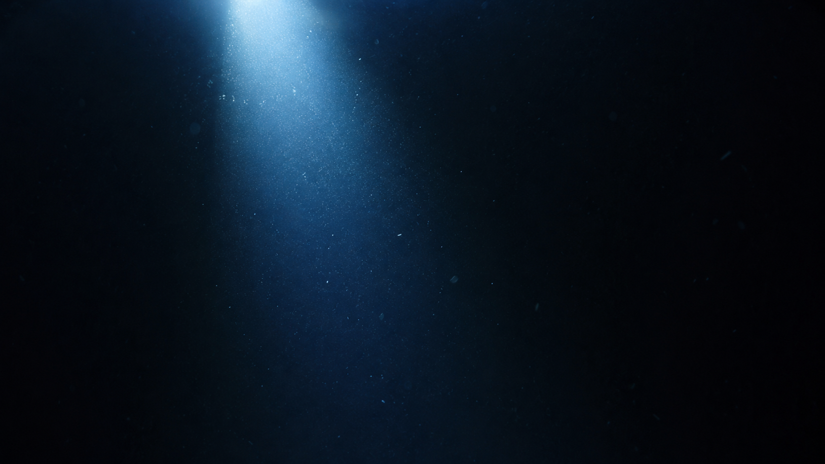 L'obscurité totale des grands fonds marins, un faisceau de lumière isolé se dissolvant dans le noir