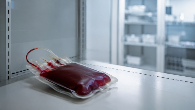 Une poche de sang posée seule sur une étagère presque vide d'un centre de transfusion