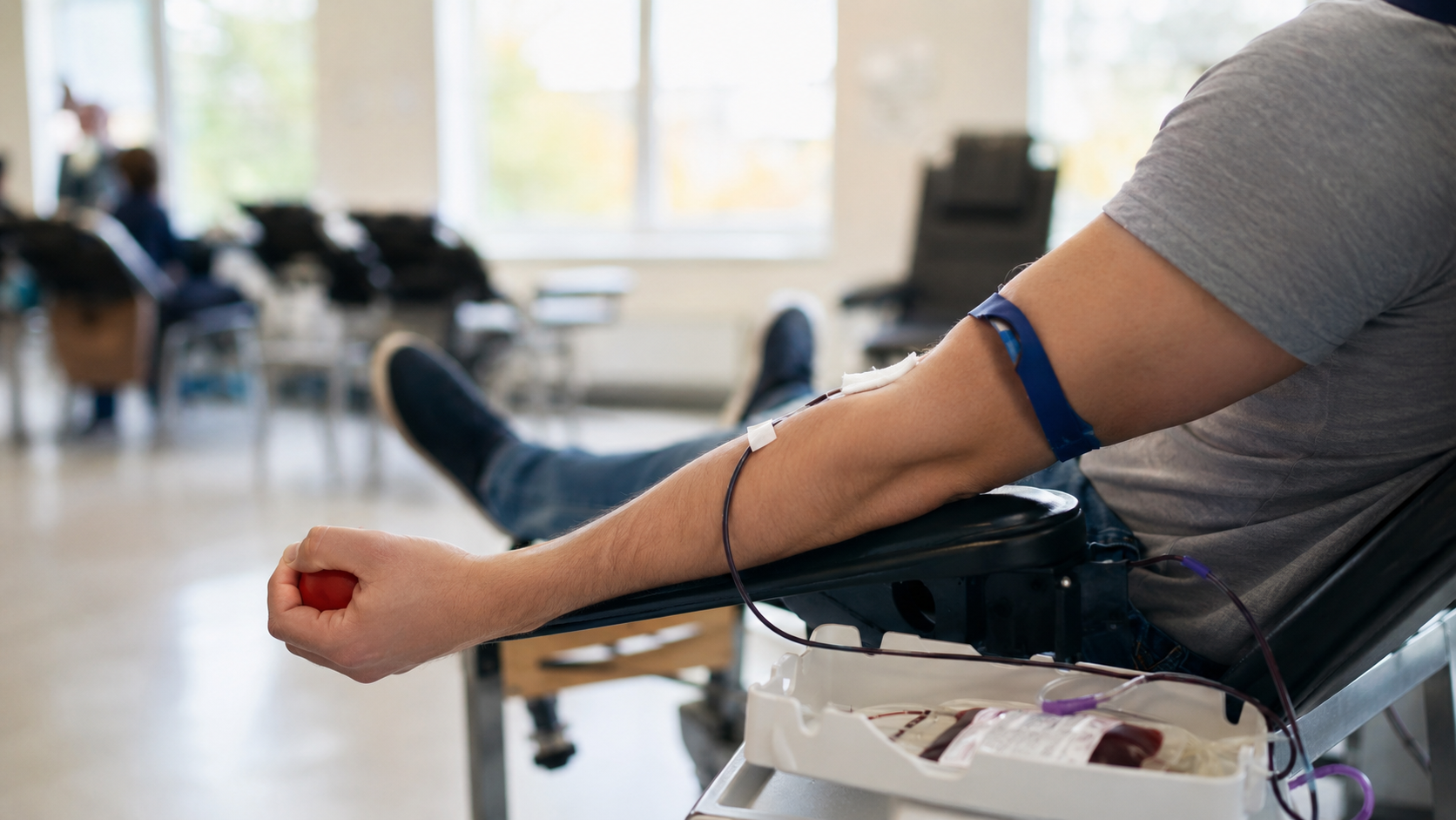 Une personne allongée sereinement dans un fauteuil de don du sang, le bras tendu
