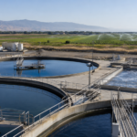 Bassins d'une station d'epuration avec un champ irrigue en arriere-plan