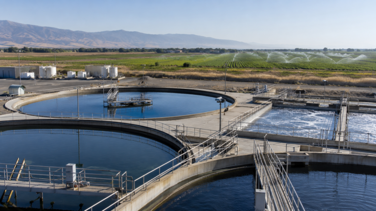 Bassins d'une station d'epuration avec un champ irrigue en arriere-plan