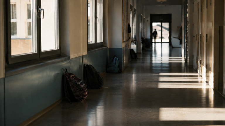 Couloir de lycée français, sacs au sol et lumière latérale, sans élèves identifiables