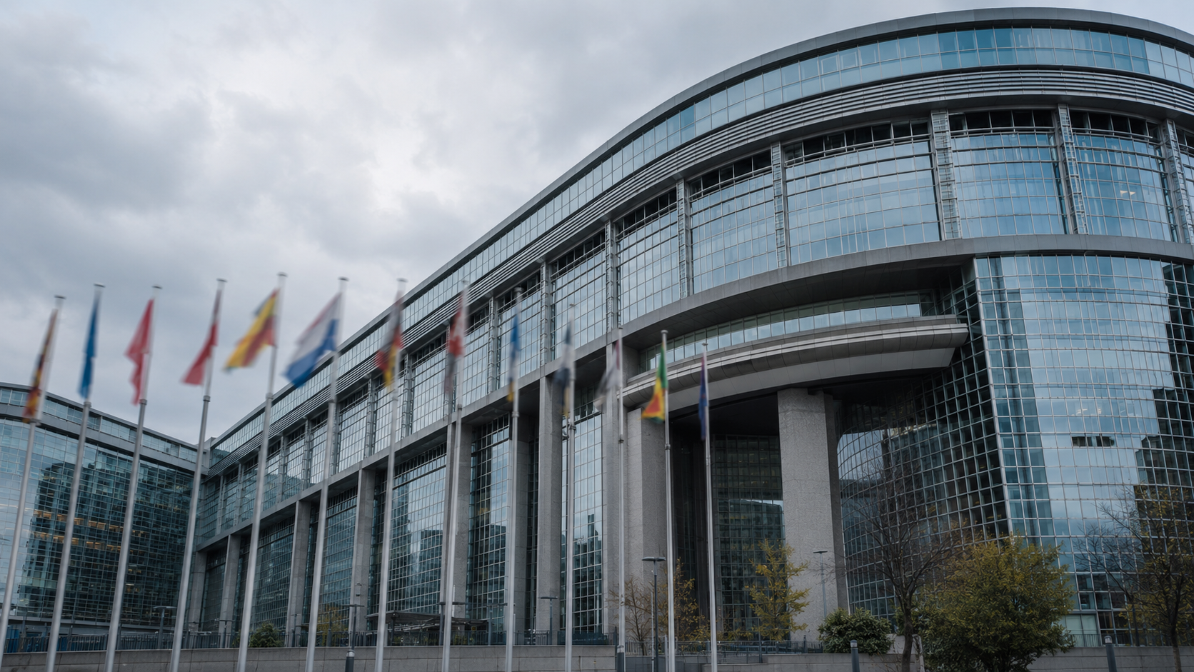 Façade vitrée d'un bâtiment institutionnel européen avec des mâts de drapeaux flous devant