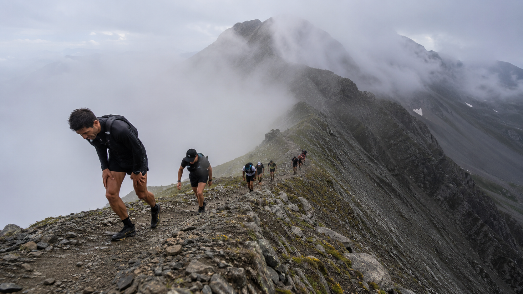 Coureurs de trail montant un sentier raide de montagne dans la brume