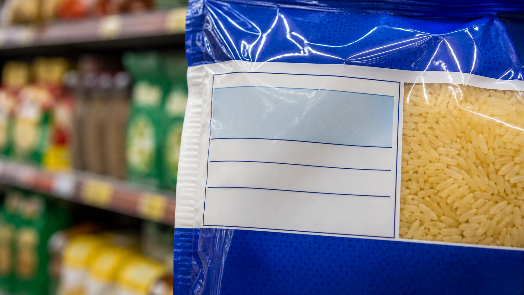 Mains tenant un paquet de snack industriel face à son étiquette dans un rayon de supermarche