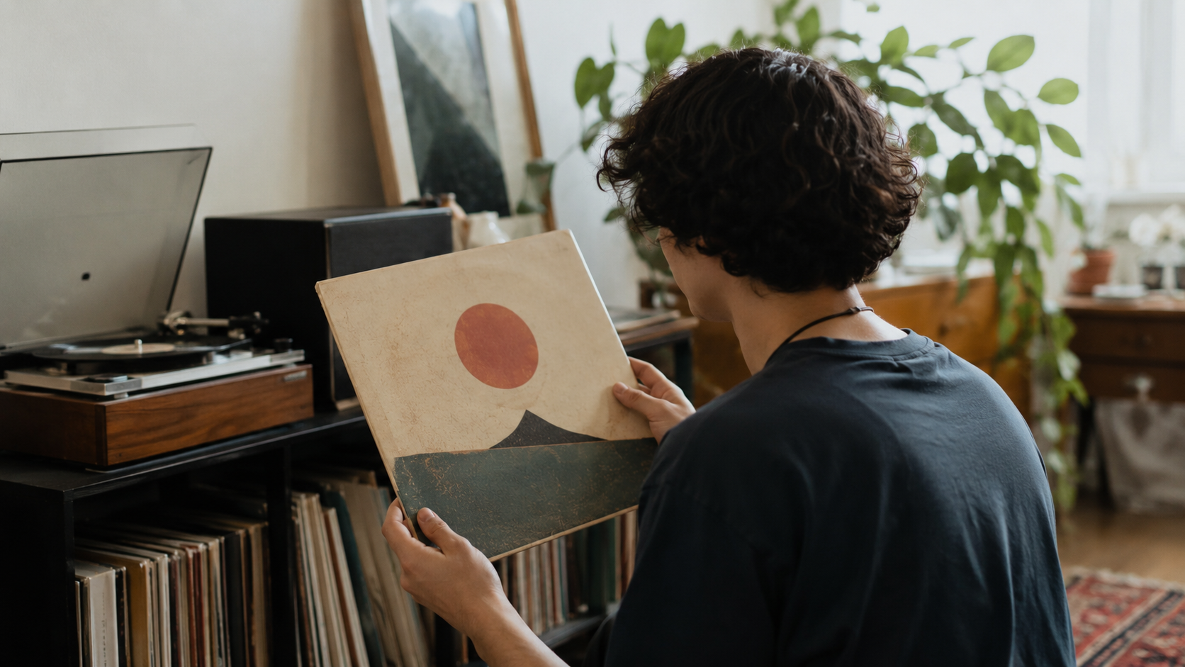 Jeune adulte tenant une pochette de vinyle dans son interieur