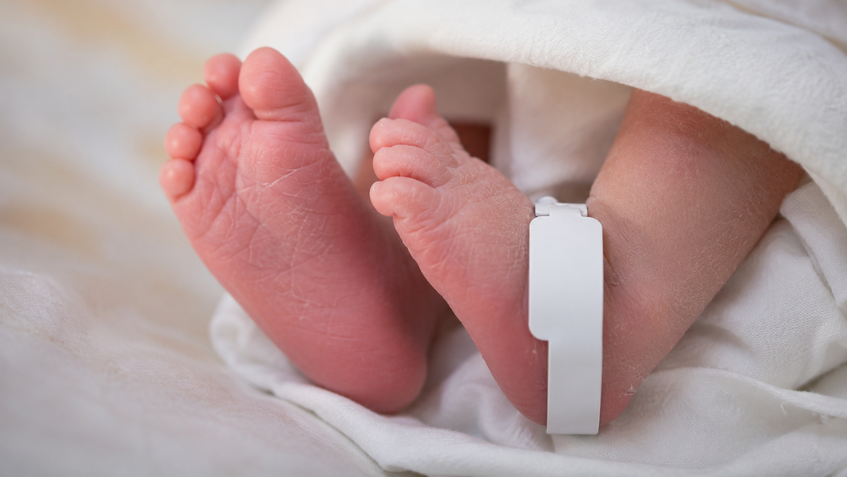Pieds d'un nouveau-né en maternité avec un bracelet d'identification vierge à la cheville