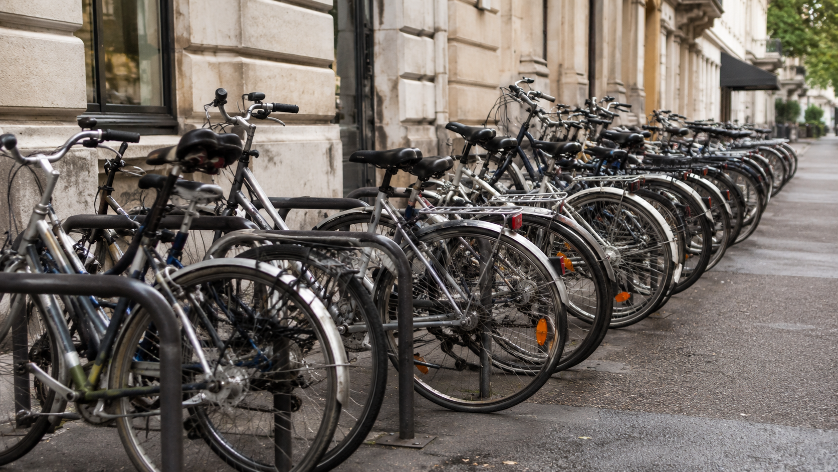 Une rangée de vélos garés côte à côte à un stationnement public en ville