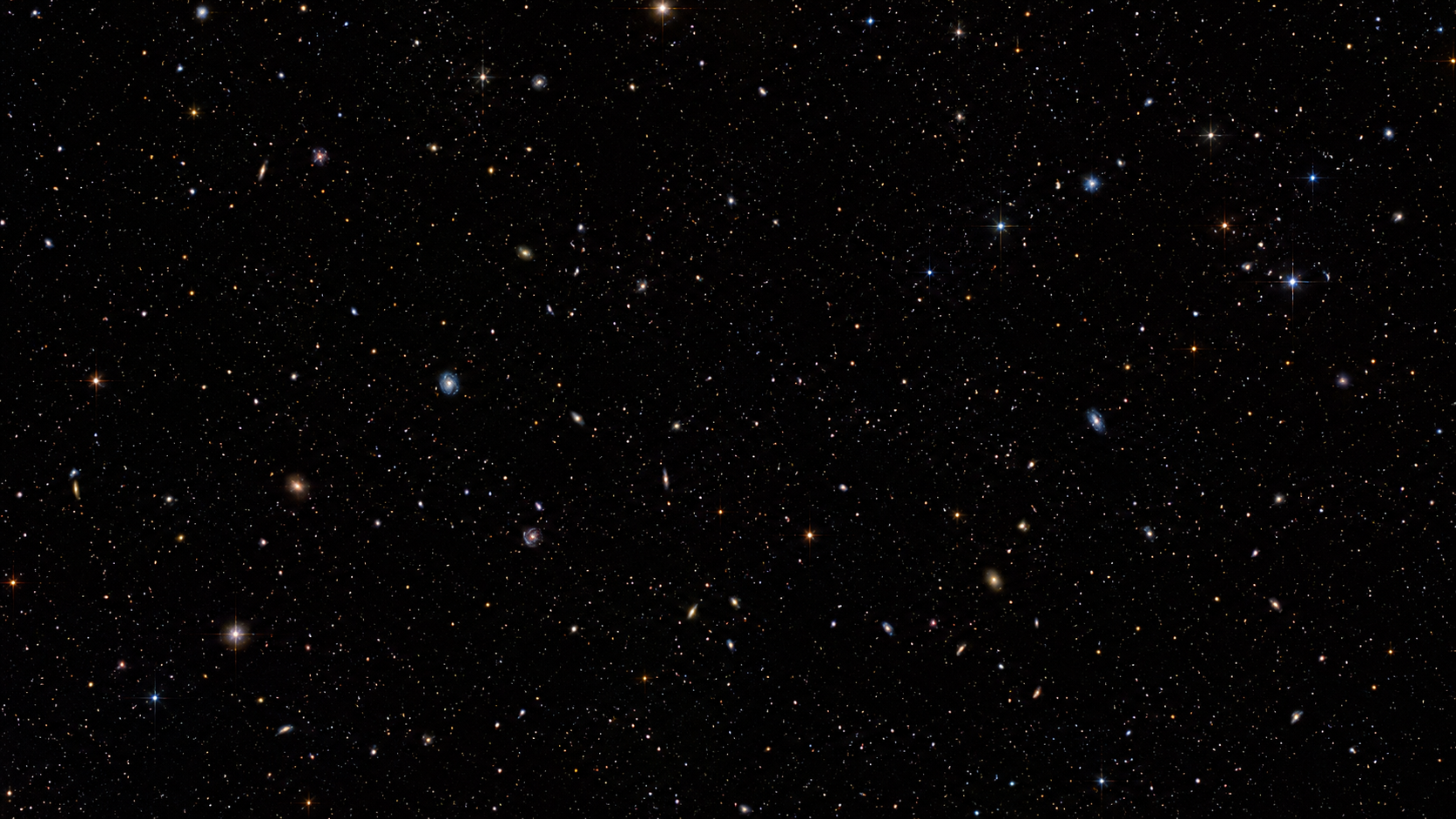 Champ profond montrant de nombreuses galaxies lointaines sur fond noir