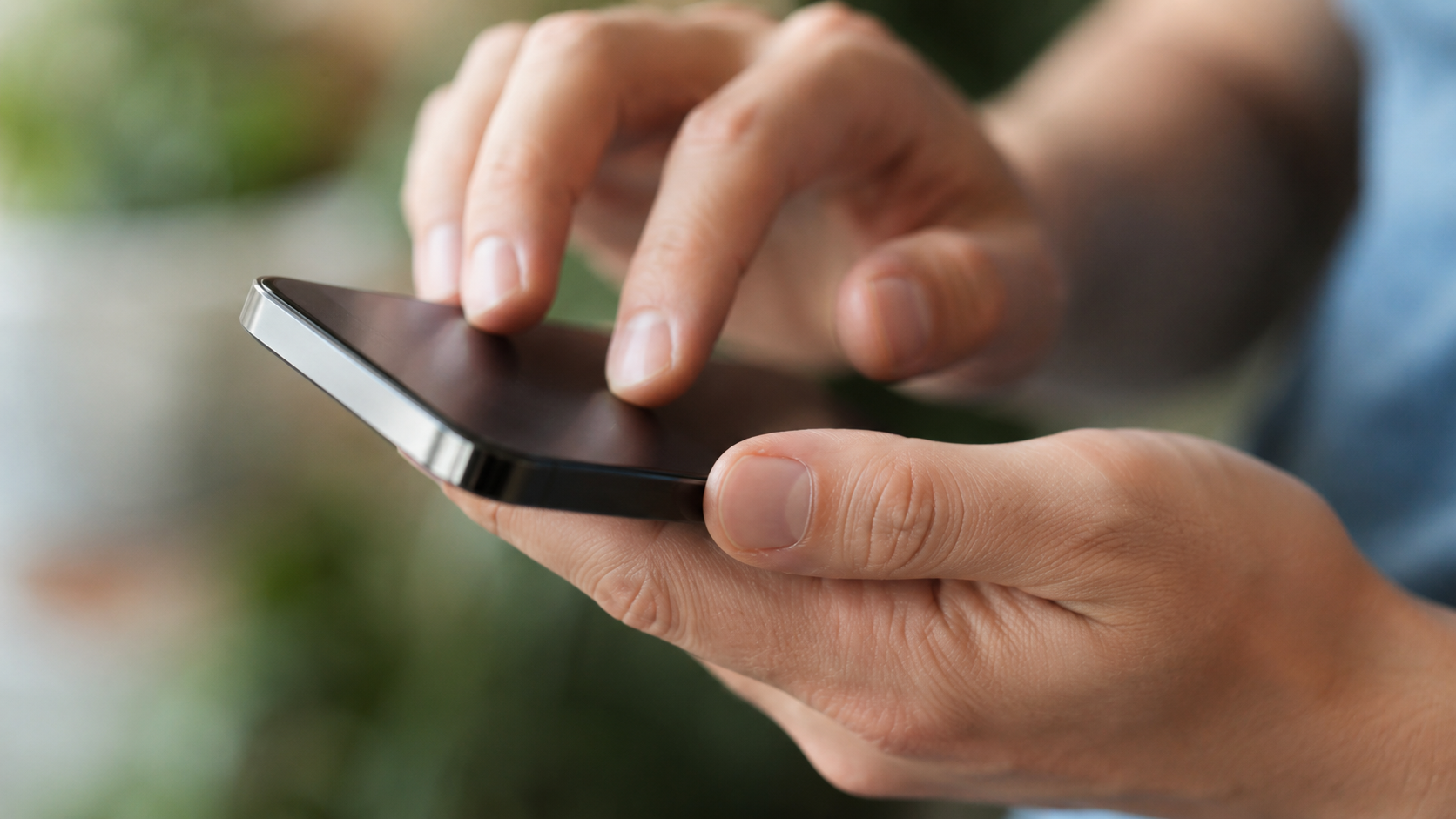 Une main règle un smartphone générique tenu dans l'autre main.