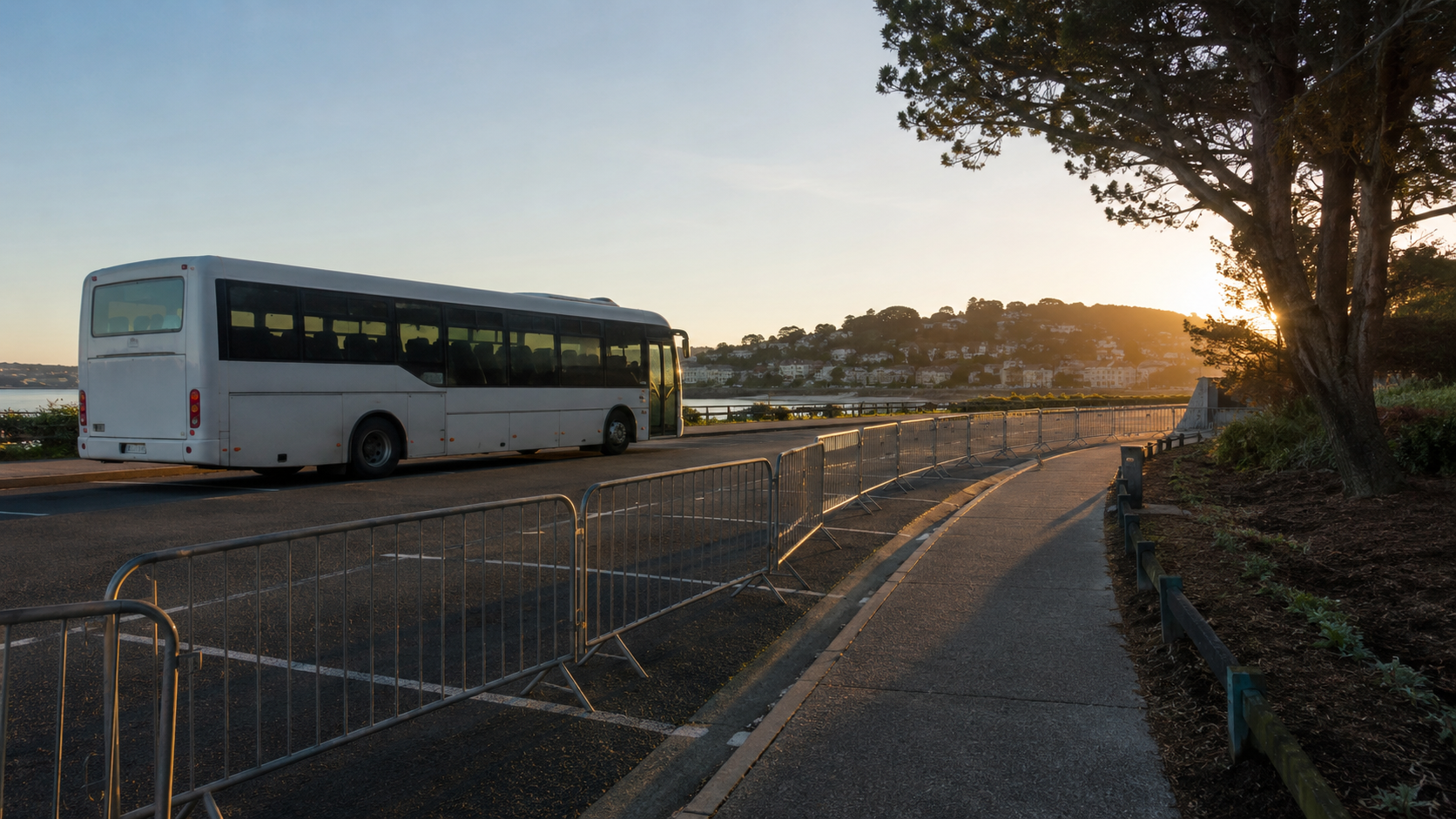 Un parking-relais au petit matin, une navette à l'arrêt et des barrières balisant un couloir piéton