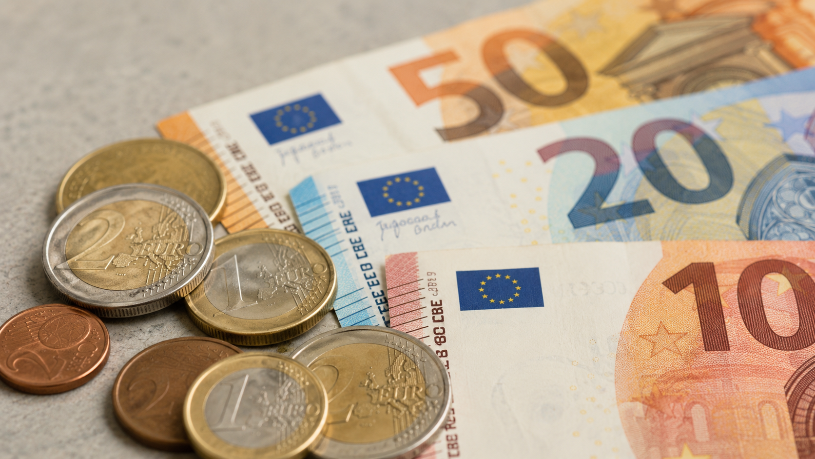 Pièces et billets en euros posés sur une surface claire
