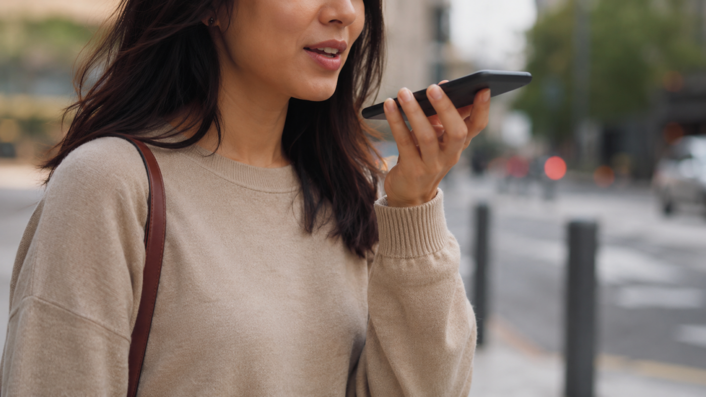 Une personne parle à son smartphone en mains libres dans la rue