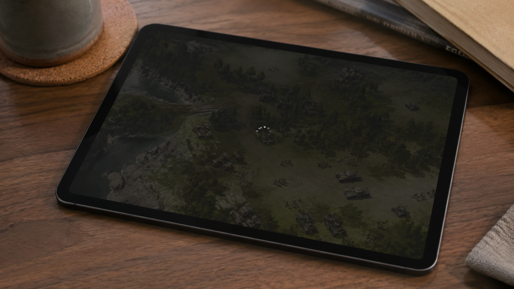 Une tablette posée sur une table affiche une partie de jeu de stratégie en temps réel