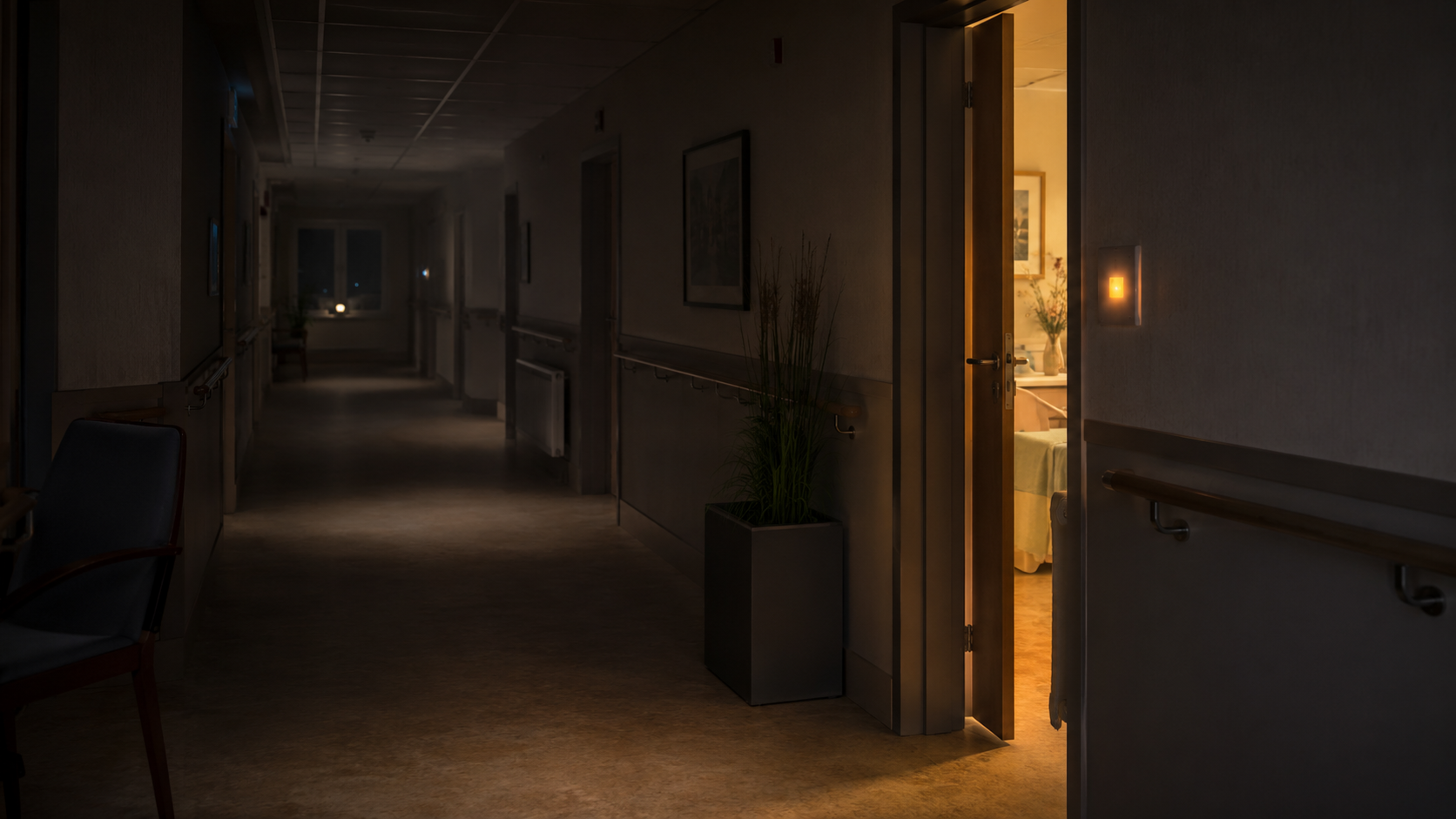 Couloir d'Ehpad faiblement éclairé la nuit, une porte de chambre entrouverte laissant filtrer une lumière chaude, voyant d'appel allumé.