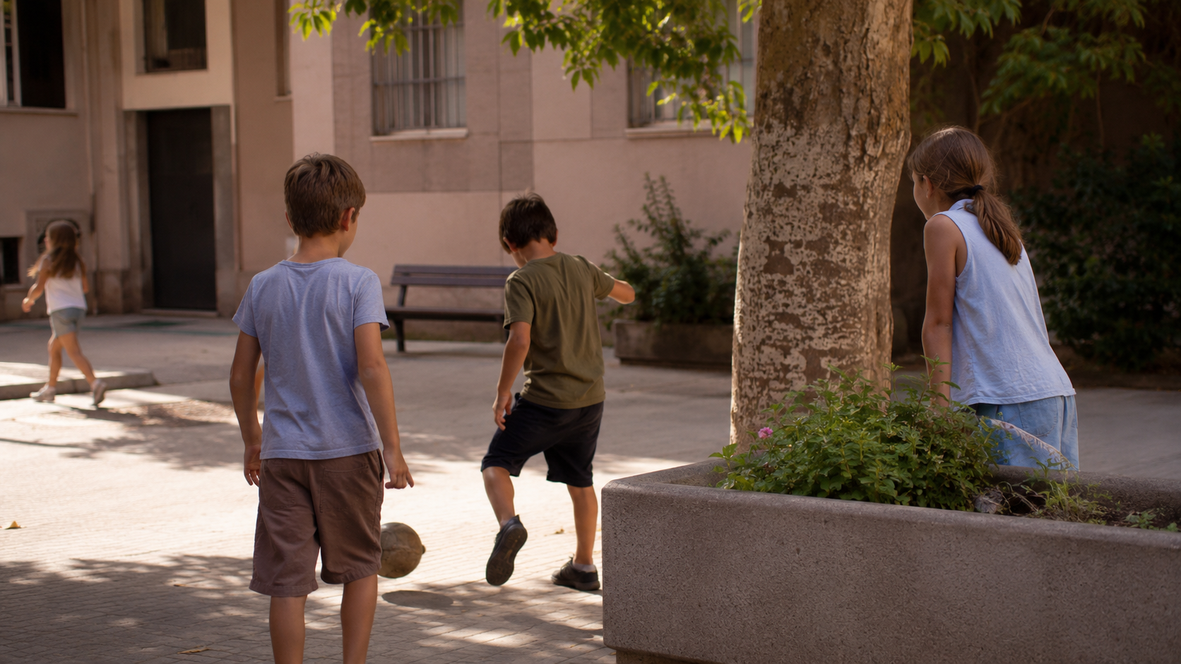 Des enfants jouent dans un square de quartier en plein été, vus de dos