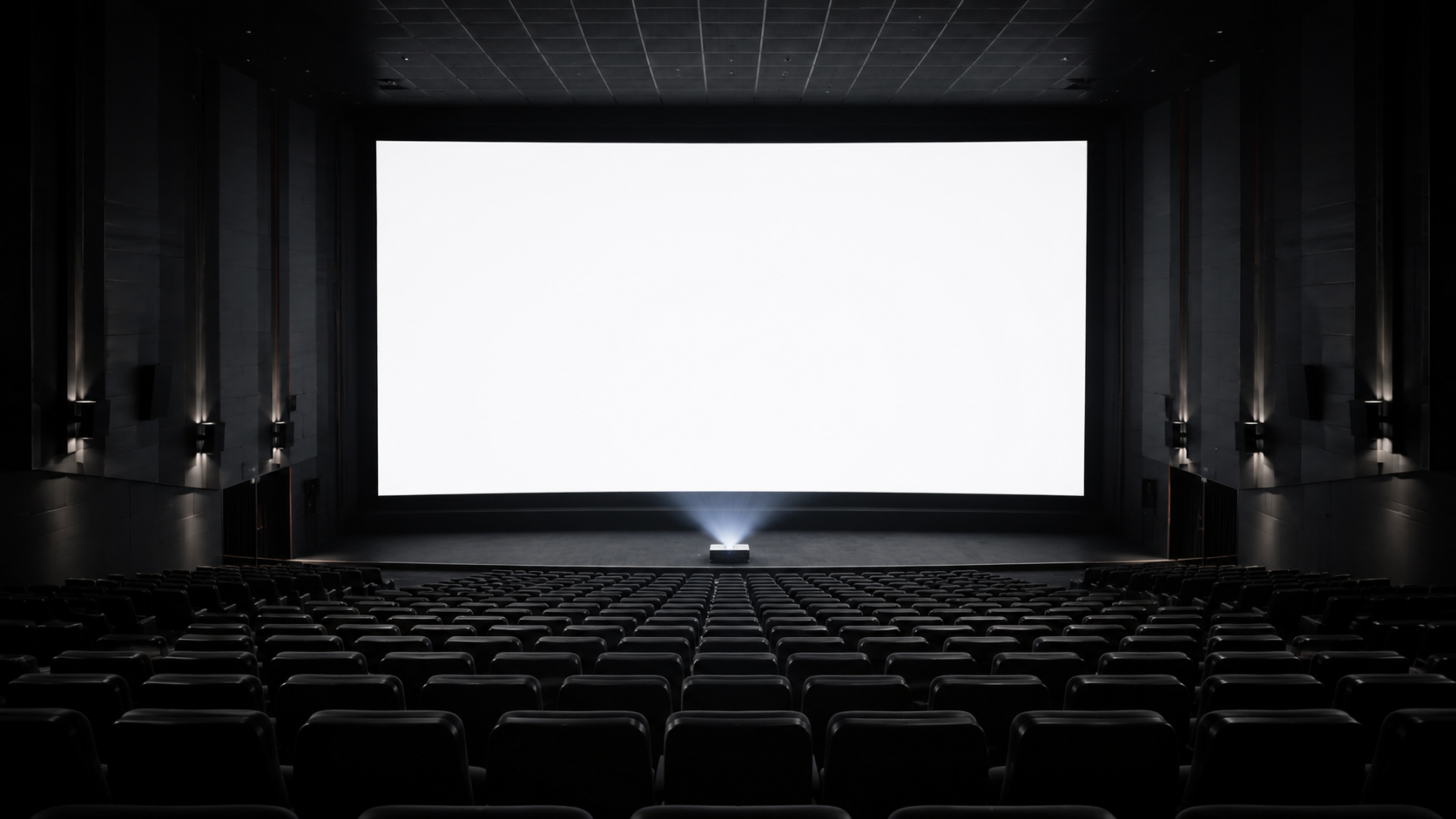 Une salle de cinéma vide vue des derniers rangs, un écran immense et blanc occupant toute la hauteur du cadre