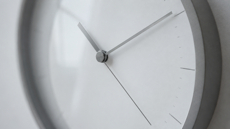 Gros plan d'un cadran d'horloge murale sobre aux aiguilles fines
